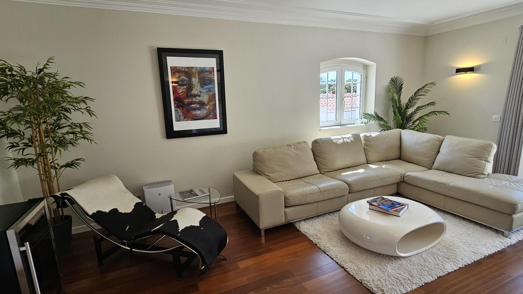 Leather sectional, chaise and arched windows in the living room at Cascais Vacation villa in Cascais, Portugal